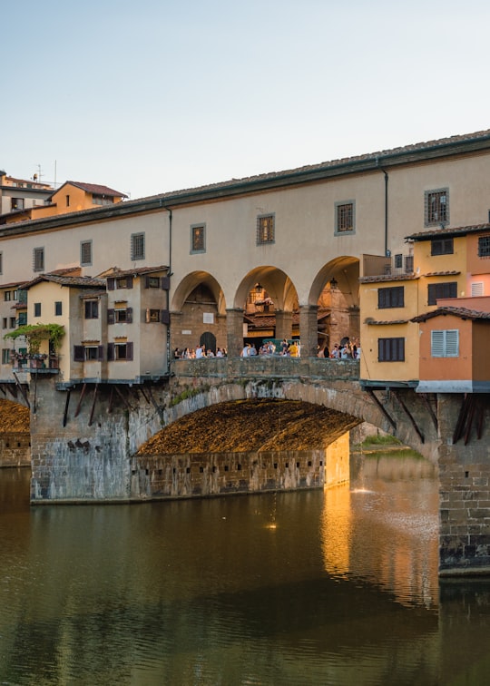 people standing on beige concrete bride in Ponte Vecchio Italy