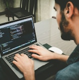 man programming using laptop