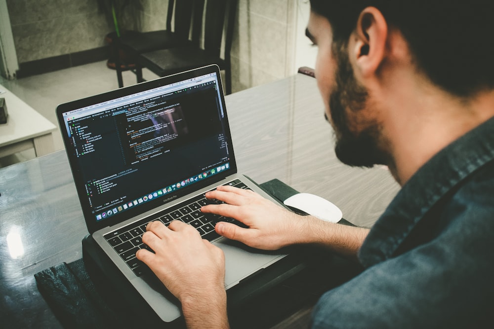 man programming using laptop