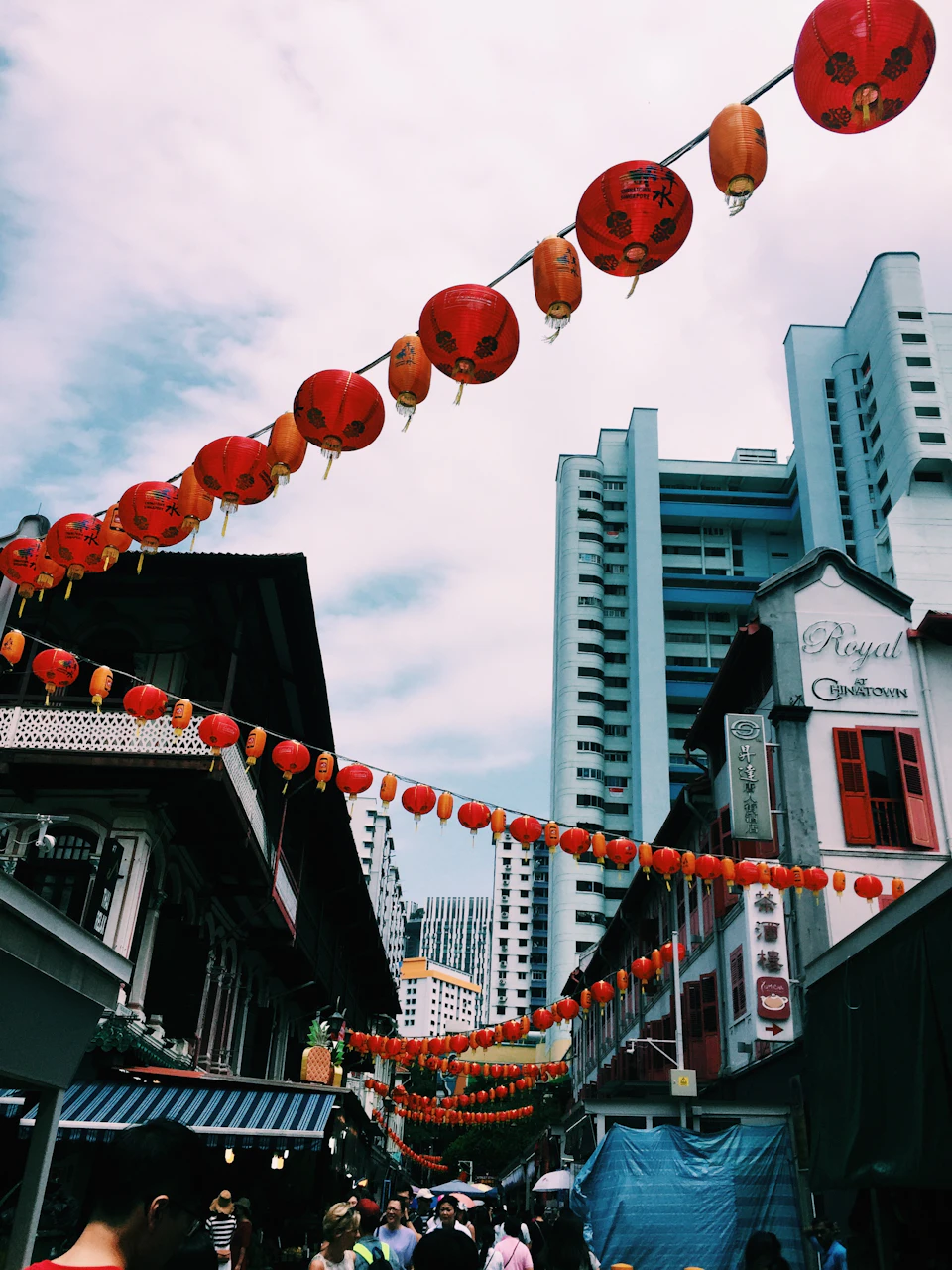 Red and orange lanterns strung above a crowded street at night during Chinese New Year