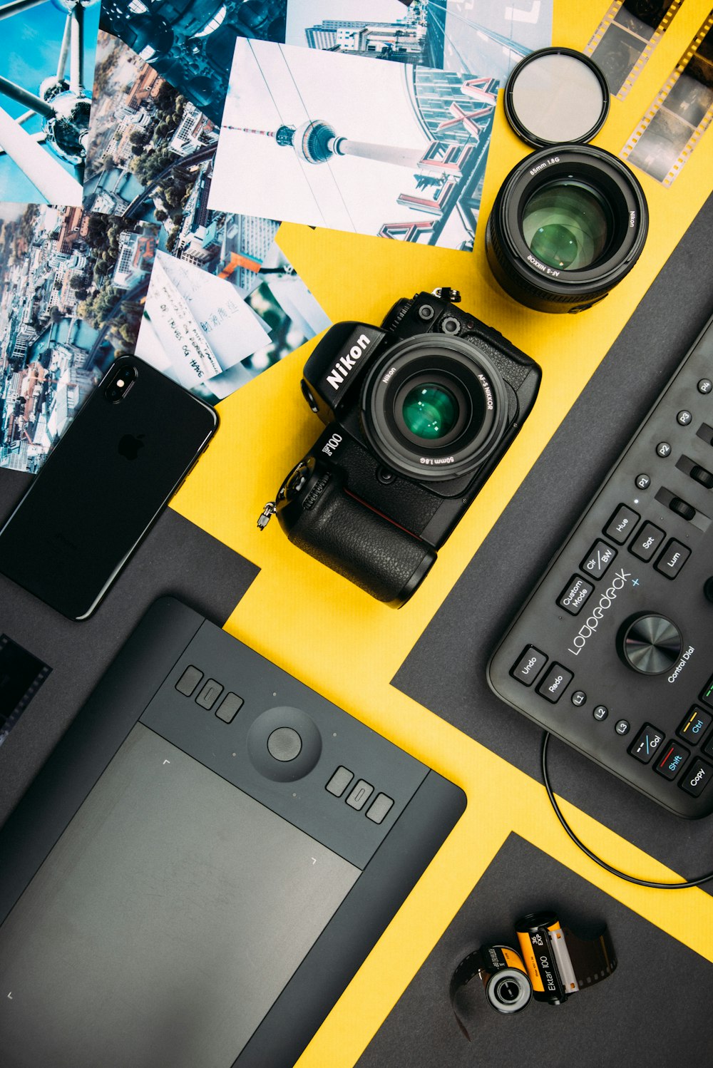 câmera DSLR Nikon preta ao lado do espaço cinza iPhone X