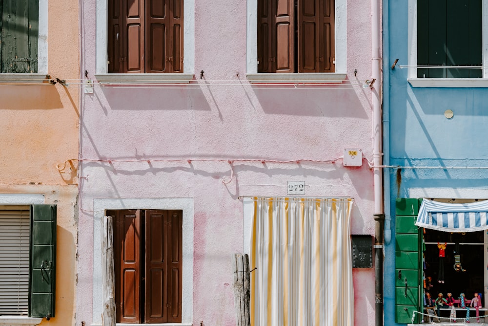 Photo d’un bâtiment rose avec un rideau de porte jaune