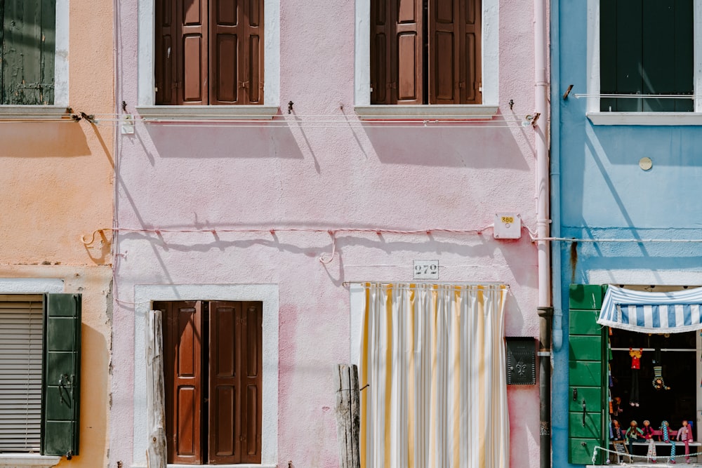photo of pink building with yellow door curtain