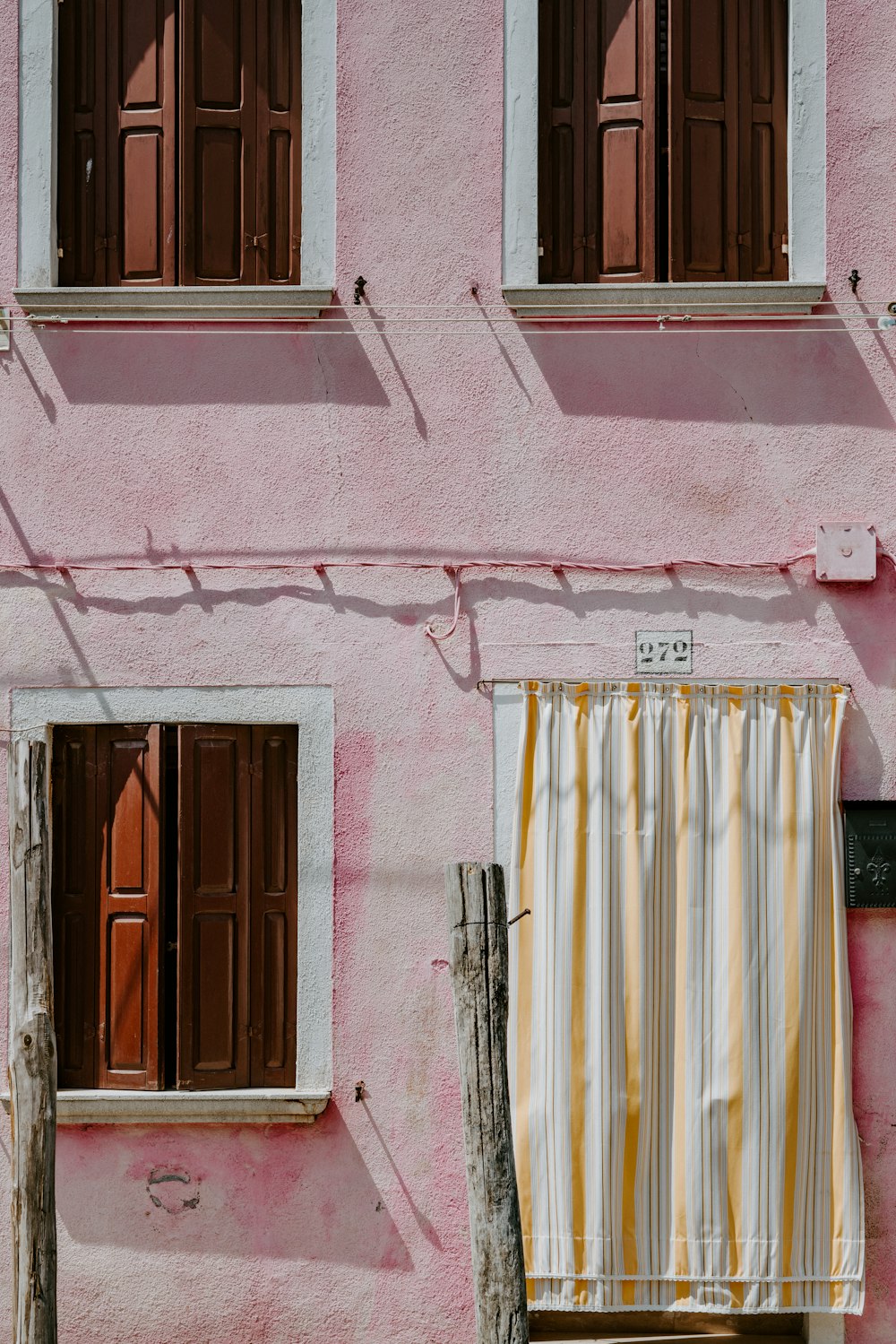 pink concrete house with three windows and one door