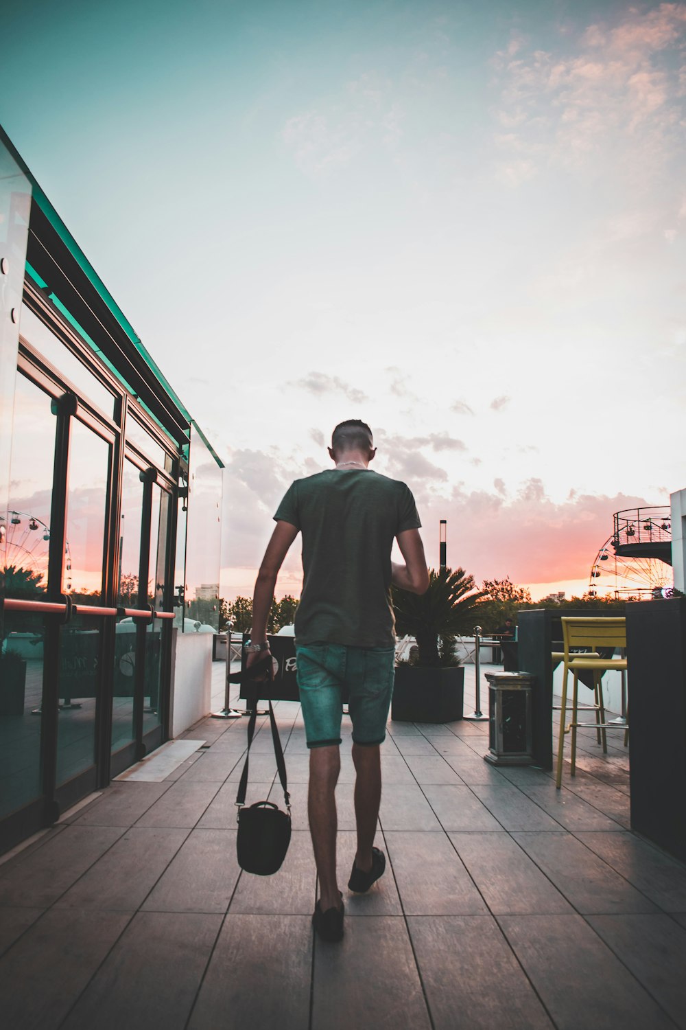 man holding black sling bag while walking