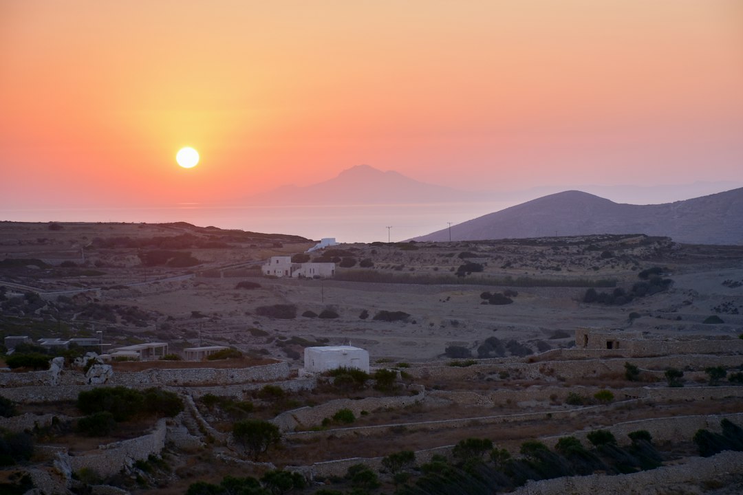 aerial photography of white buildings near mountain, Sunrise over the sea near Folegandros