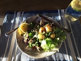 A plate of steamed fish with herbs and lemon.