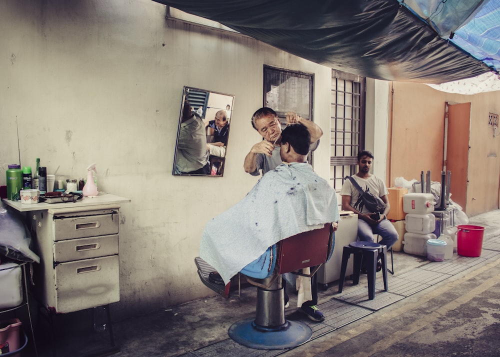 man cutting man's hair