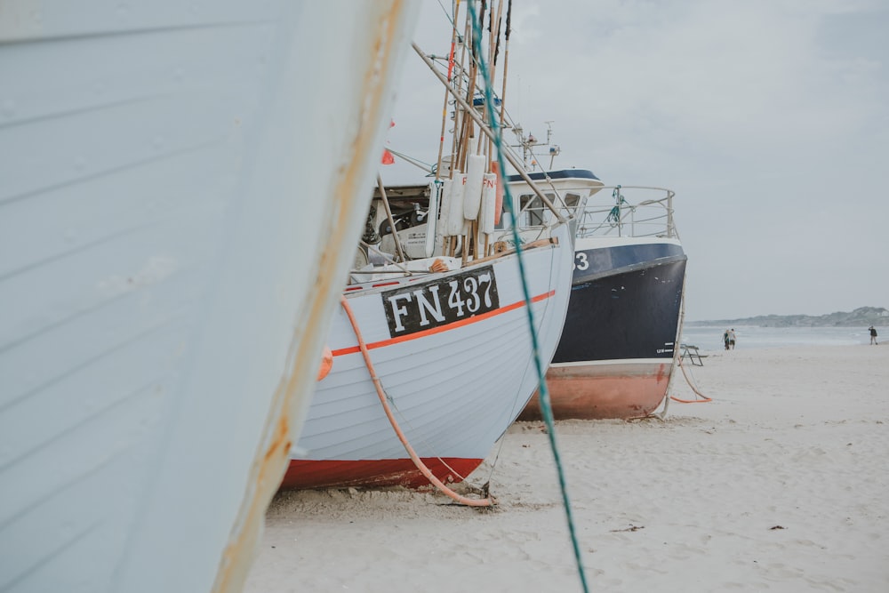 white and black boats on seashore