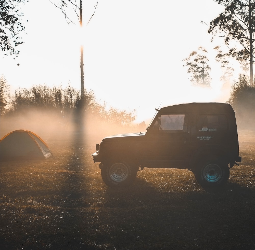 black vehicle near tent during daytime