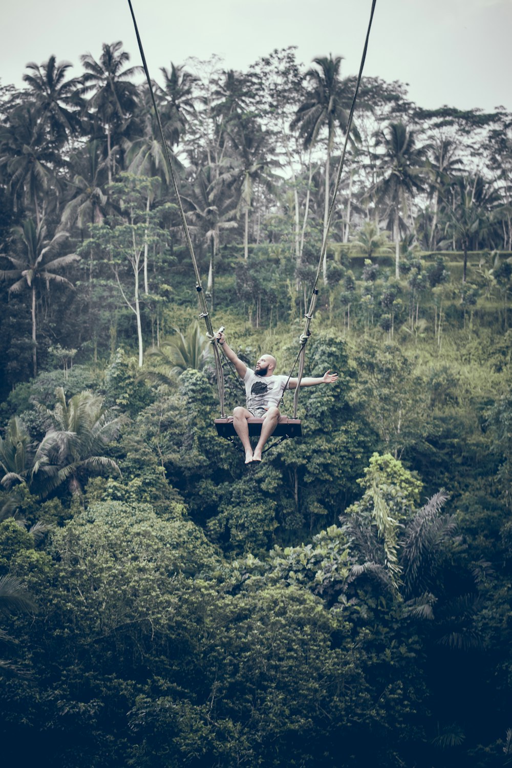 man sitting on swing chair during daytime