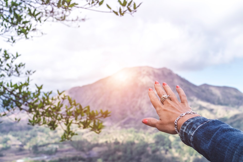 person pointing the mountain