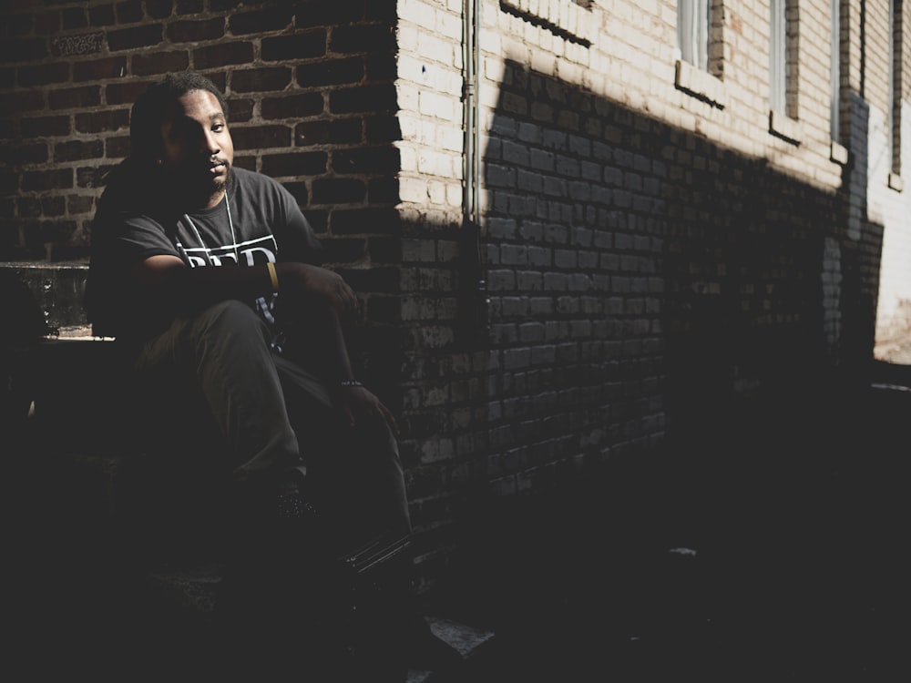 man sitting on gray staircase