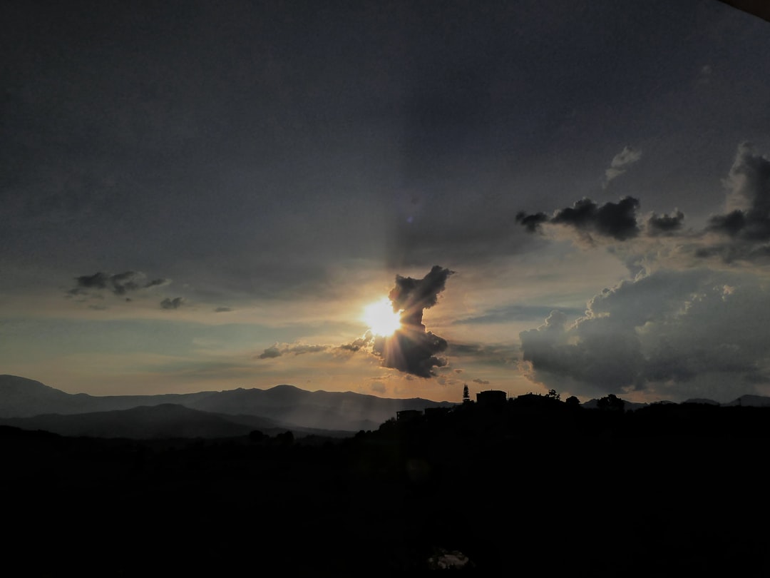 silhouette of mountain under nimbus clouds