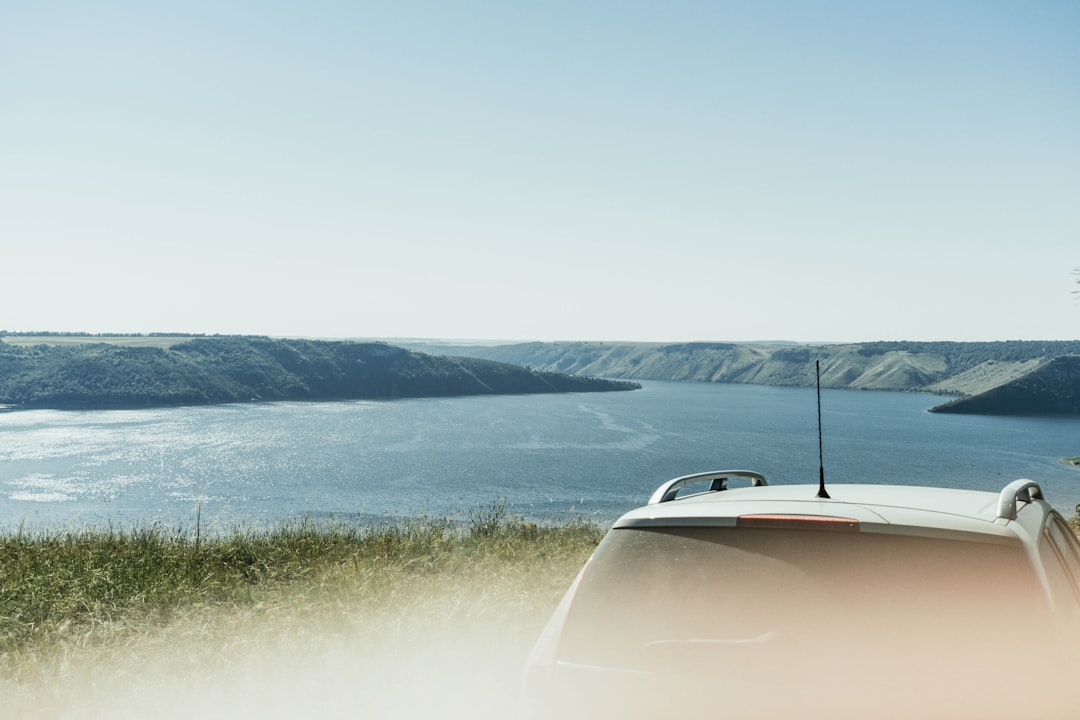 white car in front of ocean