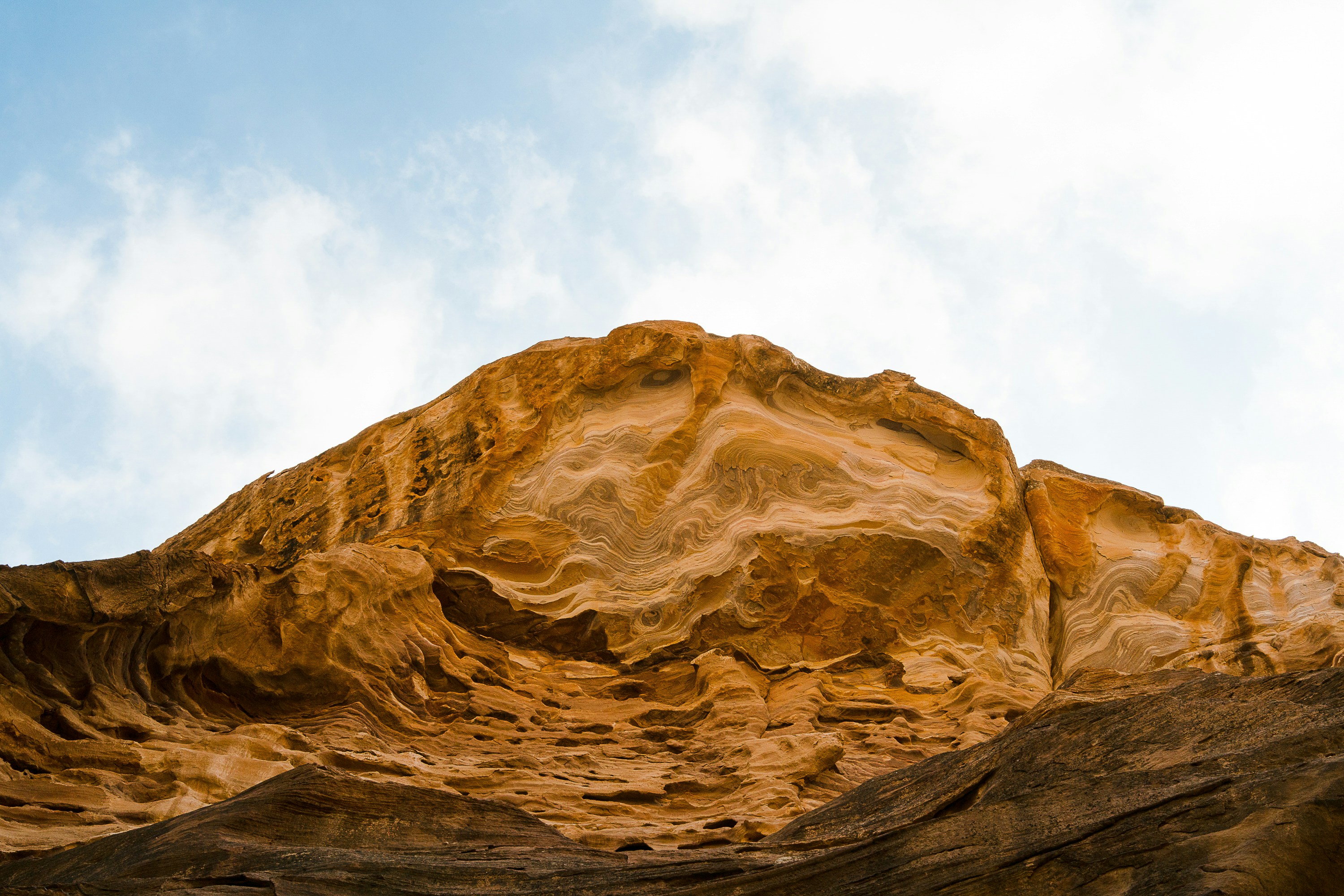 rocky hill under white and blue skies photo Free Brown Image on Unsplash