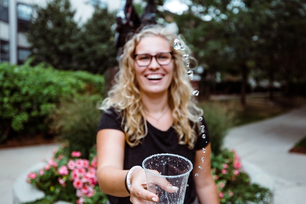 woman holding clear plastic cup