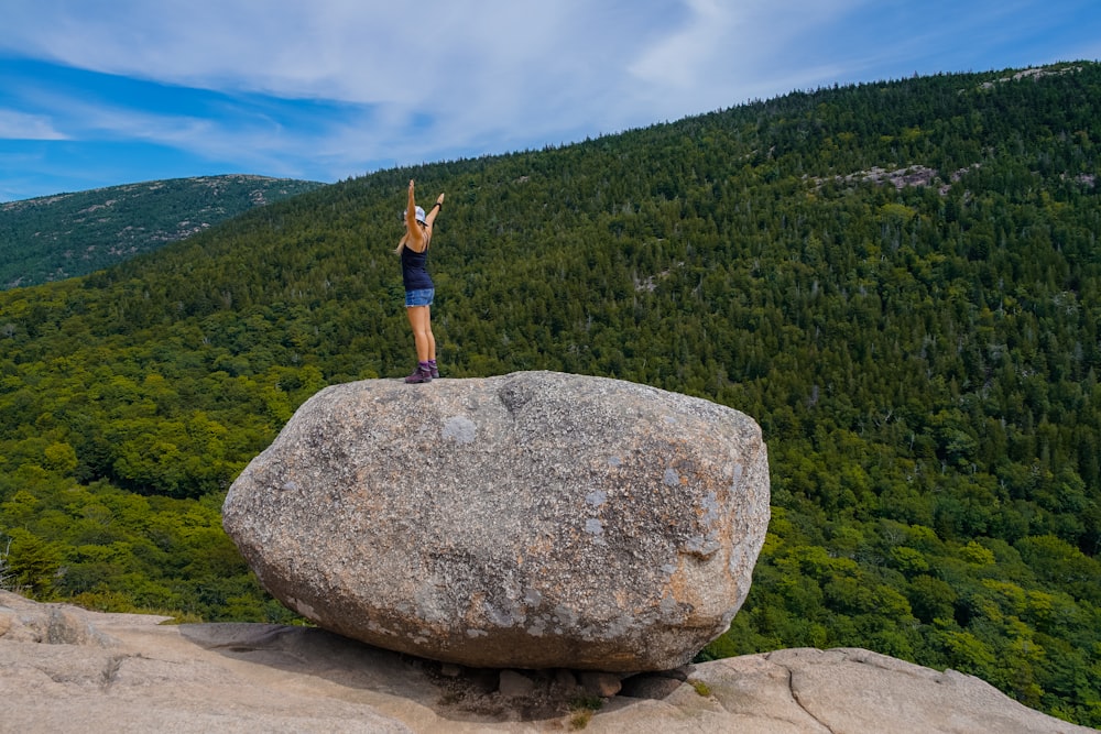Frau steht auf Felsen auf Berg