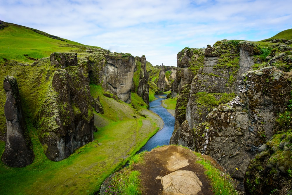 bird's eye view of lake between rock cliffs under blue sky