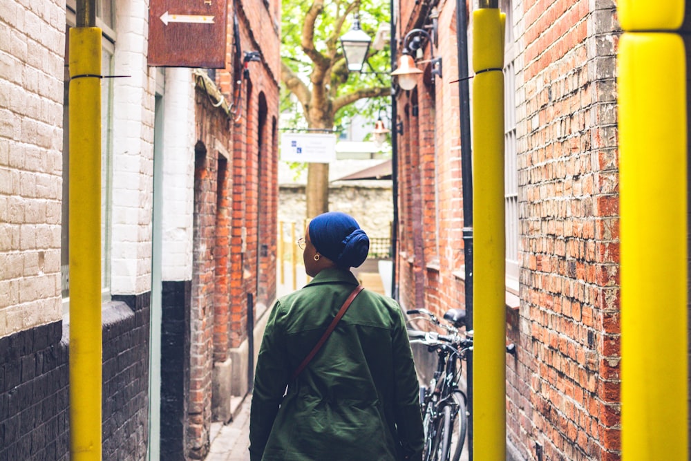 Mujer con abrigo verde caminando por la calle