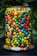 A close-up of colorful assorted candies in a glass jar.