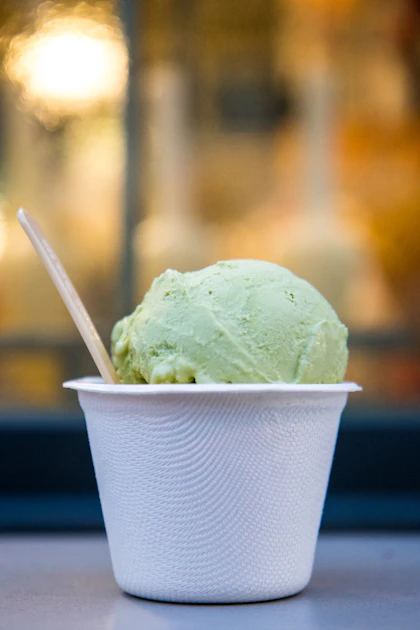 Cup of green pistachio gelato with a small spoon