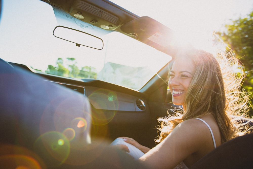 smiling woman sitting inside the vehicle at daytime