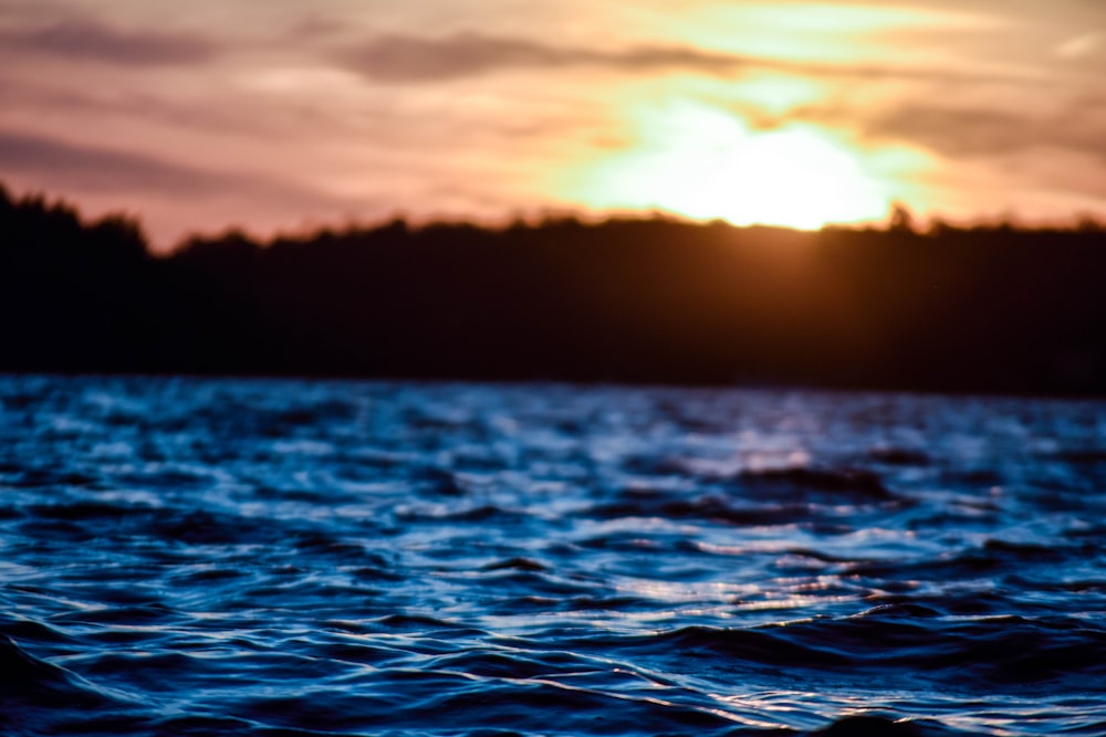 time lapse photography of body of water under golden hour