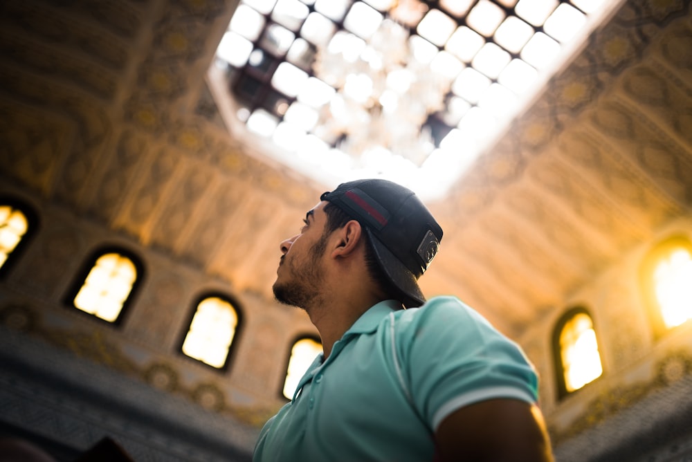 shallow focus photography of man in teal polo shirt