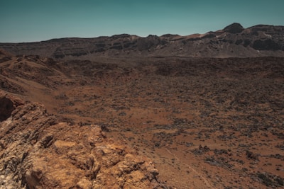 The surface of Mars showing red rocky terrain under a dusty orange sky.