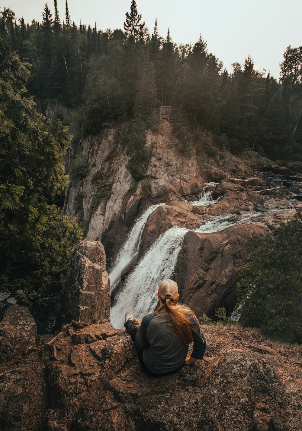 woman sitting in front of waterfalls