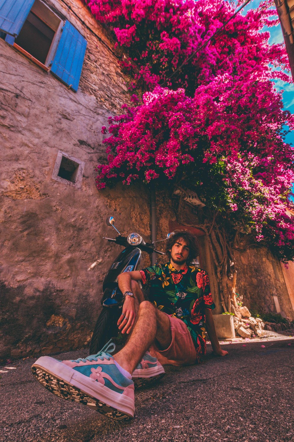 man sitting on ground beside motorcycle