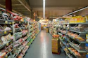 A grocery store aisle with metal shelves stocked with various packaged food products