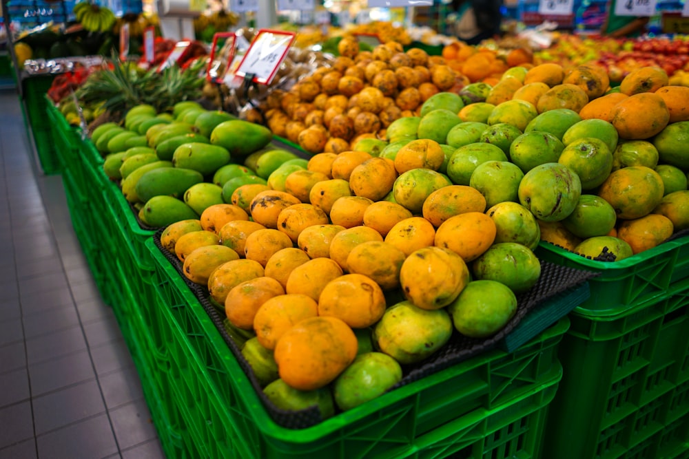 Lote de frutas de colores variados en canastas de plástico verde