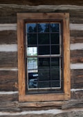 A finely crafted wooden window frame installed in a rustic home.