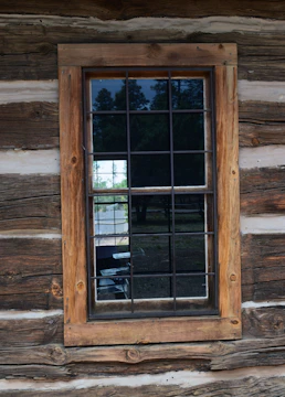 Technician carefully installing a wooden window in a cozy home setting.