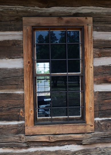 Craftsman installing a wooden window frame in a cozy home setting.