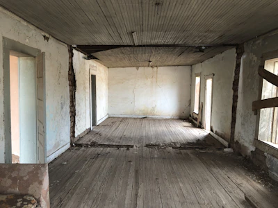 An empty, cluttered interior room in need of repair and updates.