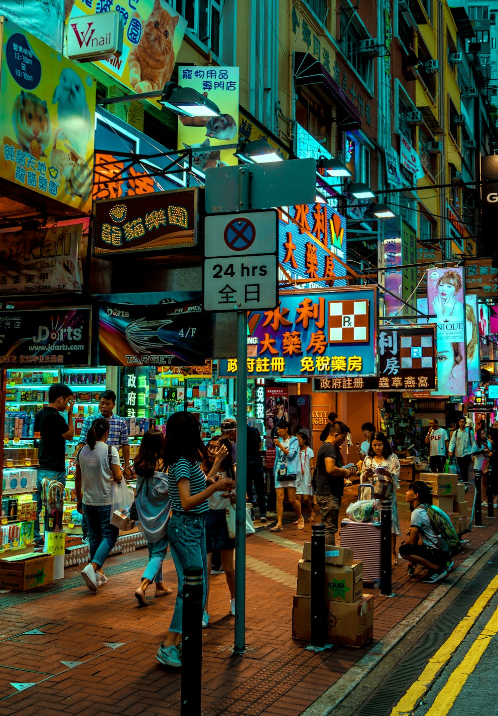 people walking on road side near stores at night time