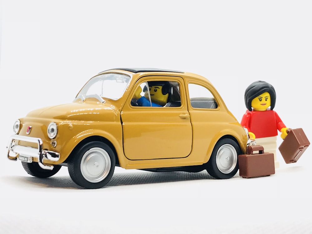 yellow Volkswagen Beetle scale model and two minifigs