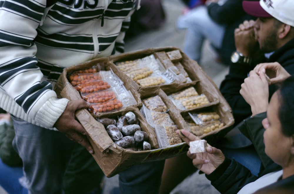 person holding cardboard box with food pack