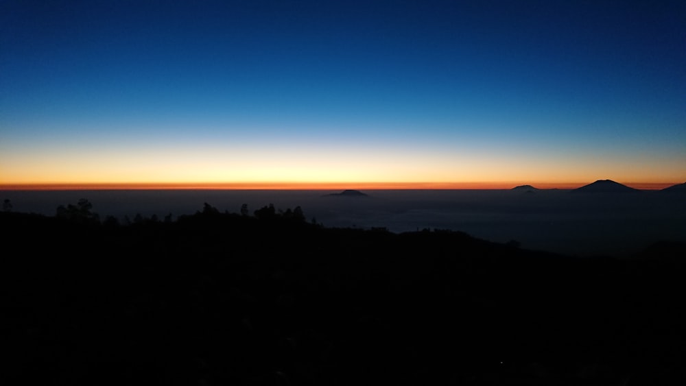 silhouette de montagnes sous un ciel bleu