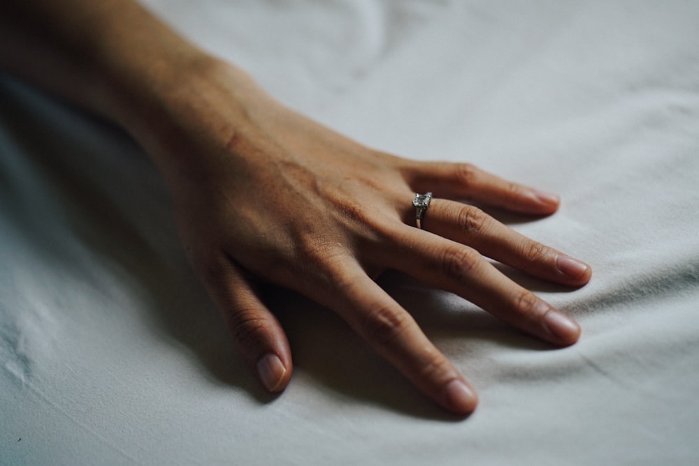 person wearing silver-colored ring