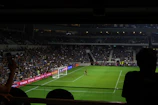 A goalkeeper making a spectacular save under bright stadium lights