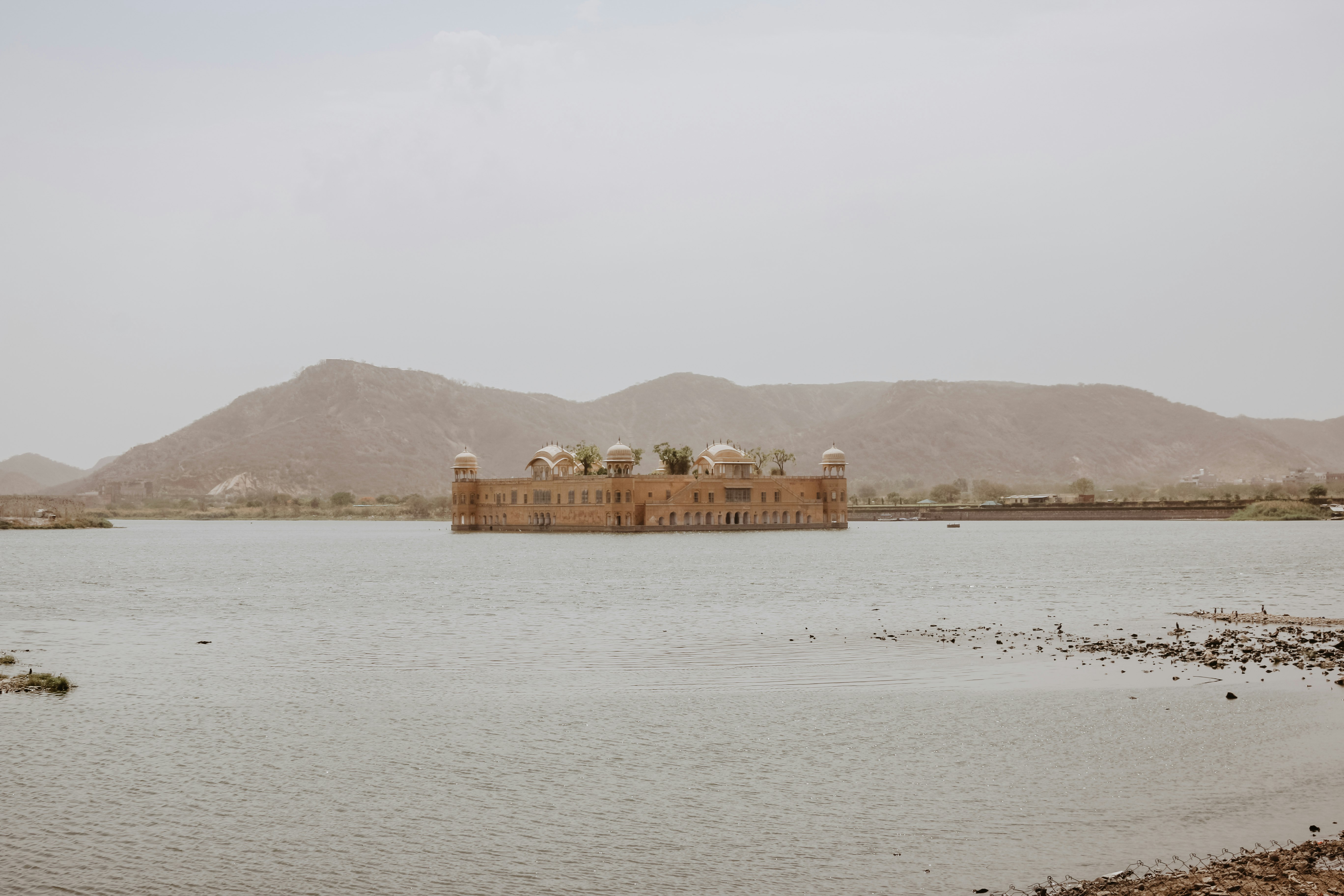 beige concrete temple surrounded by body of water