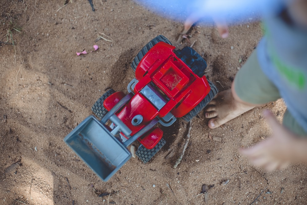 person standing beside plastic vehicle toy