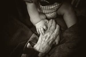 an olde"Can You Fix My Phone Again?" The Exhaustion of Being Family Tecr woman holding a baby's hand