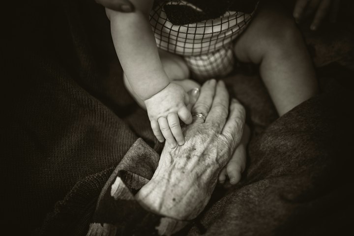 Main d'un nourrisson posée sur la main d'une grand-mère, symbole de la transmission entre générations