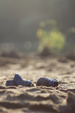 Bright, colorful close-up of casual Sponch sandals displayed on a sandy beach background