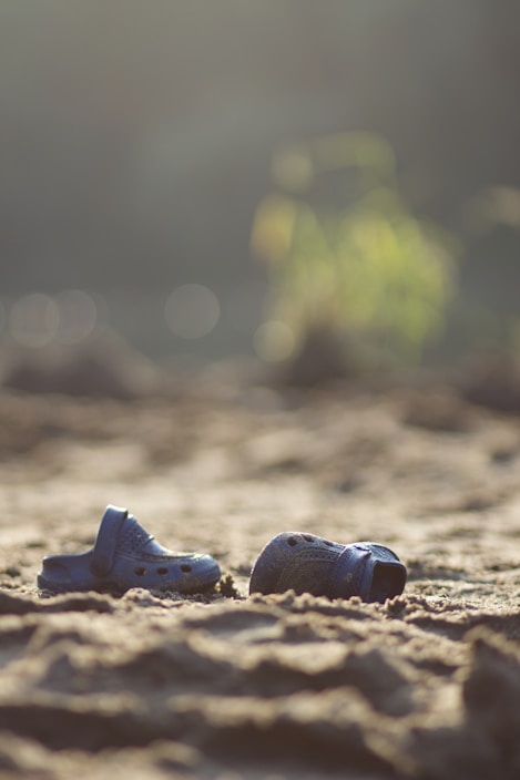 Bright, colorful close-up of casual Sponch sandals displayed on a sandy beach background